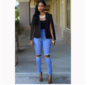 Donna con giacca nera, top nero, jeans strappati blu e tacchi leopardati. Look elegante e moderno, perfetto per moda urbana e casual chic.