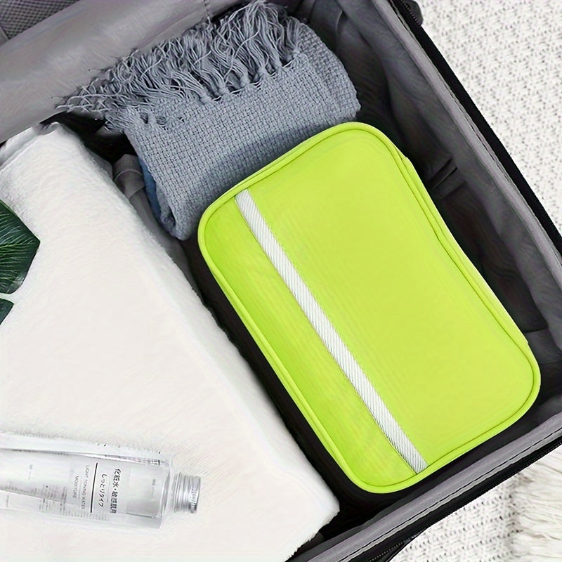 Valigia aperta con beauty case giallo, asciugamano grigio e bottiglia d'acqua. Accessori da viaggio, organizzazione bagaglio, vacanze.
