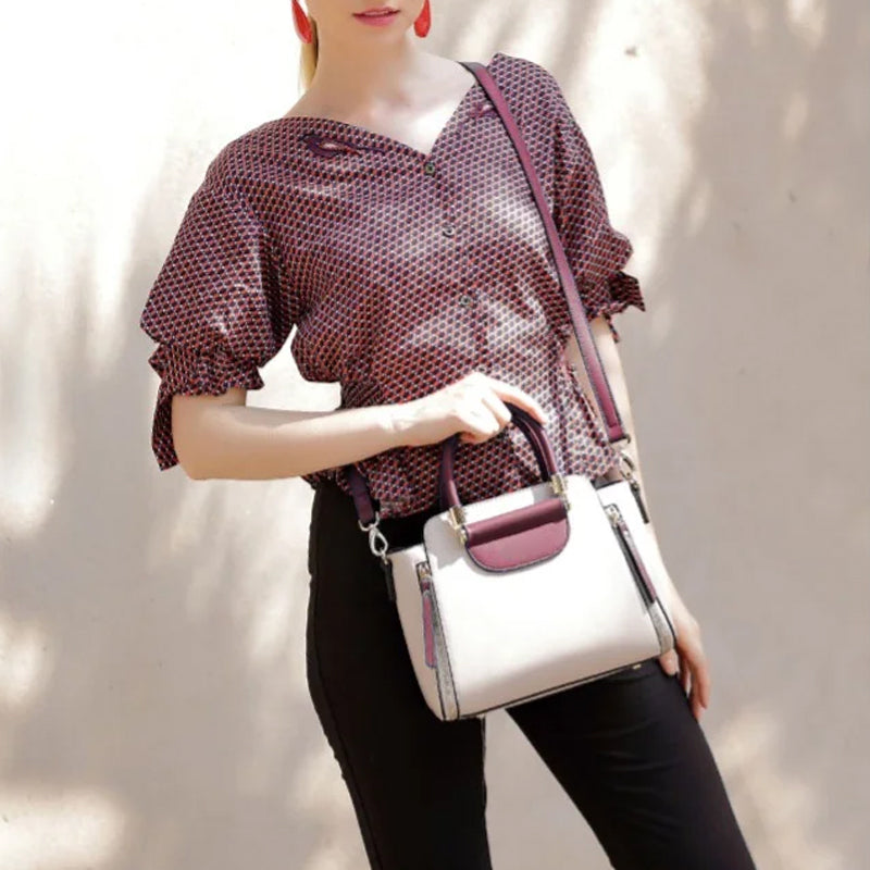 Donna con camicetta a pois rossi e borsa a tracolla bianca e bordeaux. Moda femminile, accessori eleganti, stile casual chic.