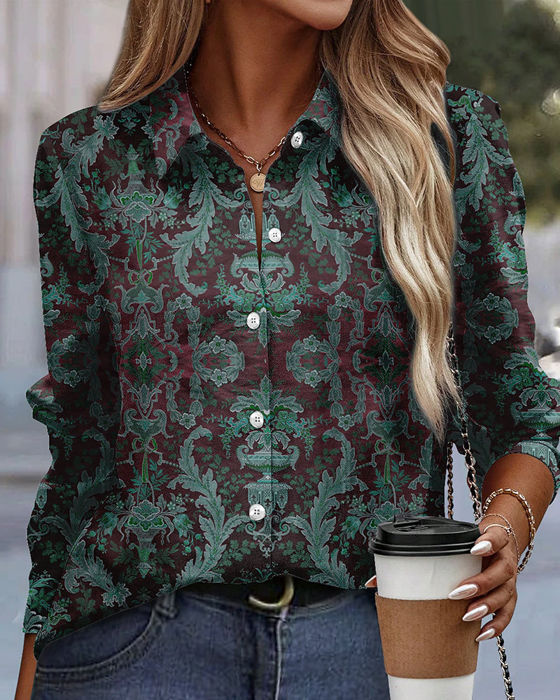 Camicia donna a maniche lunghe con motivo floreale verde e marrone, abbinata a jeans. Donna con capelli biondi tiene caffè da asporto.