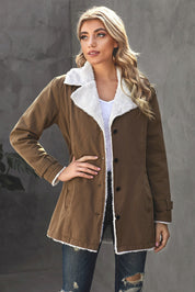Giacca donna invernale marrone con fodera in pelliccia sintetica bianca, bottoni neri, indossata su maglia bianca e jeans strappati. Moda casual elegante.