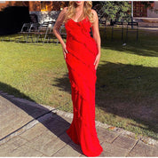 Donna in abito lungo rosso elegante con volant, posa all'aperto su prato. Moda femminile, abbigliamento da sera, tendenza abiti cerimonia.