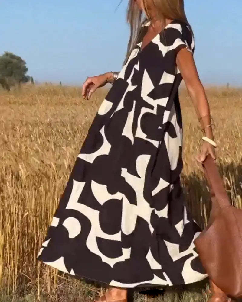 Abito lungo estivo donna, motivo geometrico bianco e nero, maniche corte, stile casual, perfetto per giornate calde, moda femminile trendy.