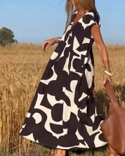 Abito lungo estivo donna, motivo geometrico bianco e nero, maniche corte, stile casual, perfetto per giornate calde, moda femminile trendy.