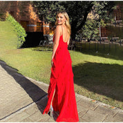 Donna in abito rosso elegante all'aperto, prato verde, sfondo alberato. Moda femminile, abito da sera, evento estivo, stile glamour.
