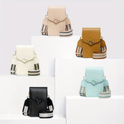 Cinque borse a tracolla colorate su piedistalli bianchi, con cinturini a righe. Colori: beige, marrone, bianco, nero, azzurro. Design elegante e moderno.