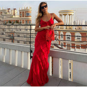 Donna in abito lungo rosso elegante su terrazza urbana, accessoriata con borsa rossa e occhiali da sole. Moda femminile, abbigliamento serale.