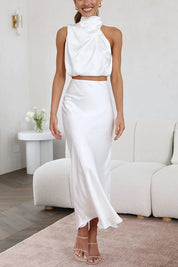 Abito da sera bianco elegante, senza maniche, con gonna lunga e top asimmetrico. Perfetto per eventi formali e cerimonie.