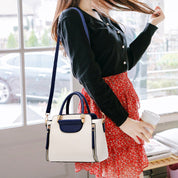 Donna con borsa a tracolla bianca e blu, indossa cardigan nero e gonna rossa a fiori, tiene una tazza da caffè. Moda casual elegante.