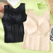 Due corsetti modellanti in tessuto elasticizzato, uno nero e uno beige, su sfondo verde. Design senza maniche, chiusura a ganci. Indumenti intimi modellanti.
