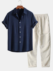 Camicia blu a maniche corte con bottoni bianchi e pantaloni beige in lino, abbigliamento estivo casual uomo, moda leggera e traspirante.