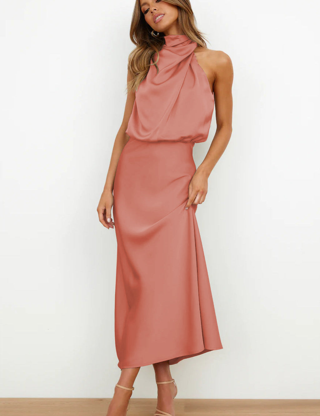 Abito lungo elegante rosa salmone con scollo all'americana, indossato da donna in piedi. Perfetto per eventi formali e serate speciali.