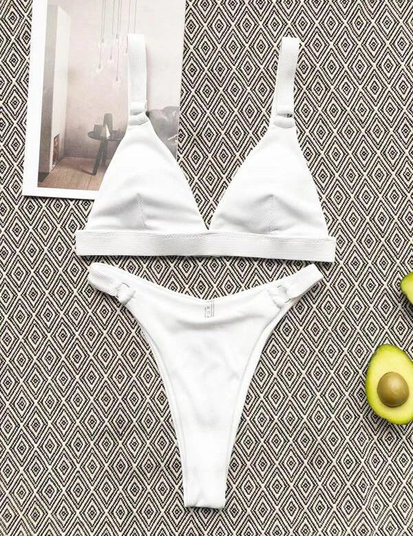 Bikini bianco a triangolo su sfondo geometrico, con avocado e rivista. Costume da bagno estivo, moda mare, stile minimalista.