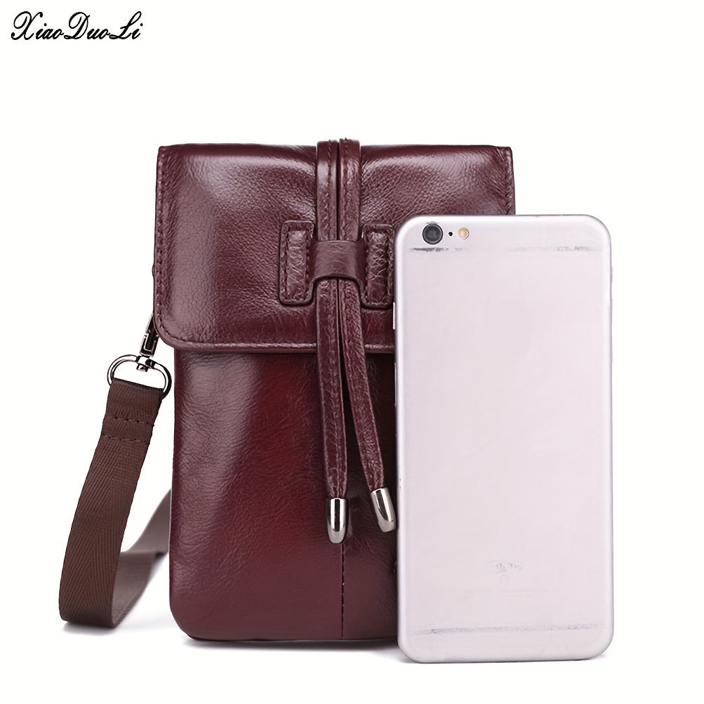 Borsa a tracolla in pelle marrone con chiusura a coulisse, accanto a uno smartphone per confronto dimensioni. Accessorio moda elegante e pratico.