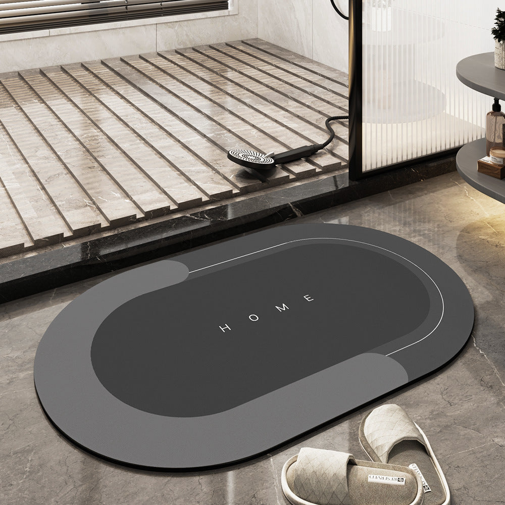 Tappeto da bagno antiscivolo grigio scuro, design moderno con scritta "HOME", posizionato su pavimento in marmo vicino a doccia e pantofole.