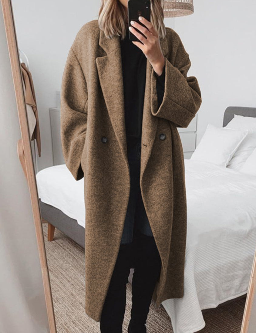 Donna con cappotto oversize marrone, specchio, camera da letto moderna, moda autunnale, abbigliamento casual elegante, selfie allo specchio.