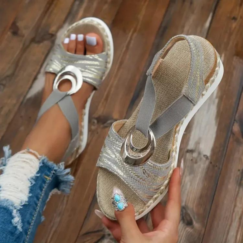 Sandali estivi da donna con zeppa, colore argento, dettagli metallici, suola in gomma bianca. Ideali per look casual e alla moda.