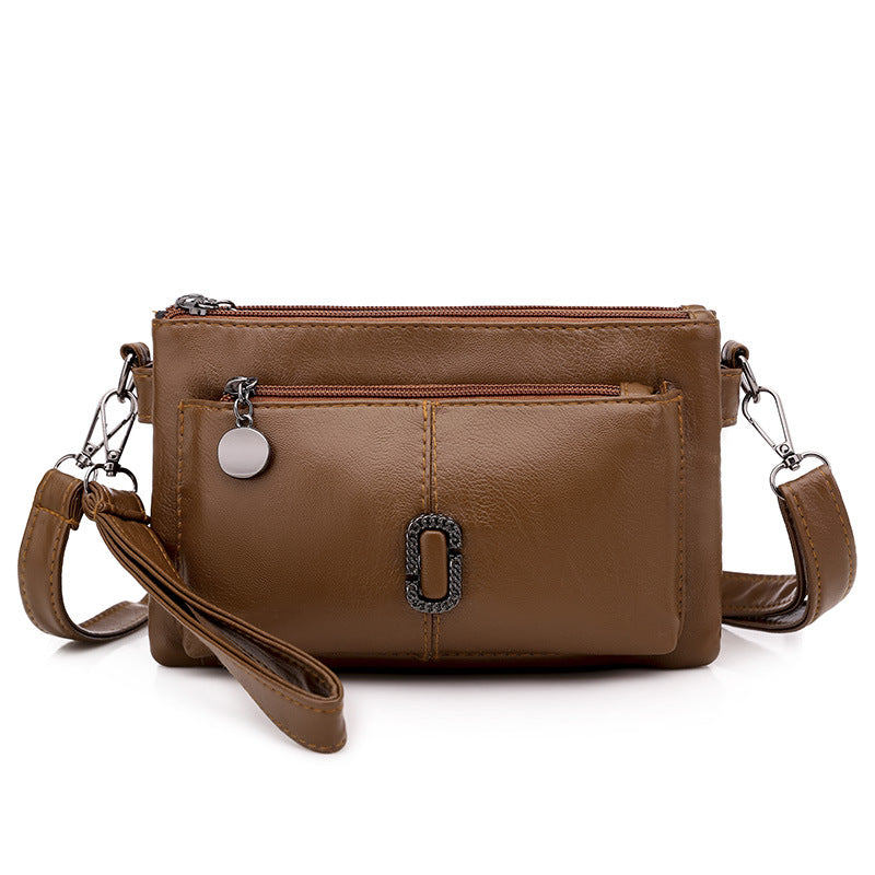 Borsa a tracolla in pelle marrone con tasche multiple e cerniere, design elegante e pratico, ideale per donna, accessorio moda versatile.