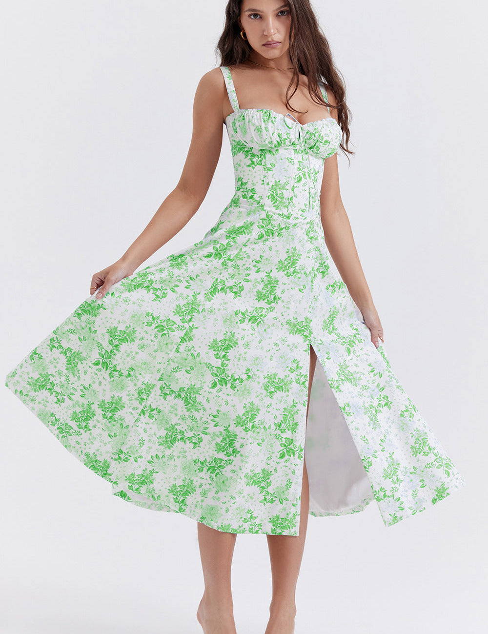 Abito estivo donna bianco con stampa floreale verde, spalline sottili, scollo a cuore e spacco frontale. Elegante e alla moda per occasioni estive.