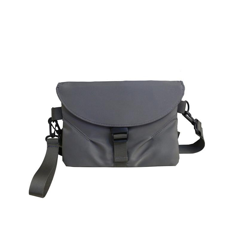 Borsa a tracolla grigia unisex, design moderno, chiusura a fibbia, regolabile, ideale per viaggi e uso quotidiano. Accessorio moda versatile.