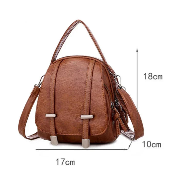 Zaino in pelle marrone, dimensioni 18x17x10 cm, con manico superiore e tracolla regolabile. Design elegante e compatto per moda e praticità.