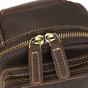 Zaino in pelle marrone con doppia cerniera robusta e cuciture a contrasto. Design elegante e resistente, ideale per viaggi e uso quotidiano.