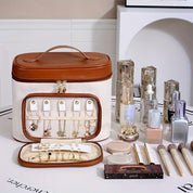 Elegante organizer per gioielli e cosmetici in pelle marrone e bianca, con scomparti per anelli, collane e trucchi. Accessori beauty e skincare inclusi.