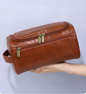 Borsello da viaggio in pelle marrone con doppia cerniera, manico laterale, design elegante e spazioso. Accessorio ideale per uomo e donna.