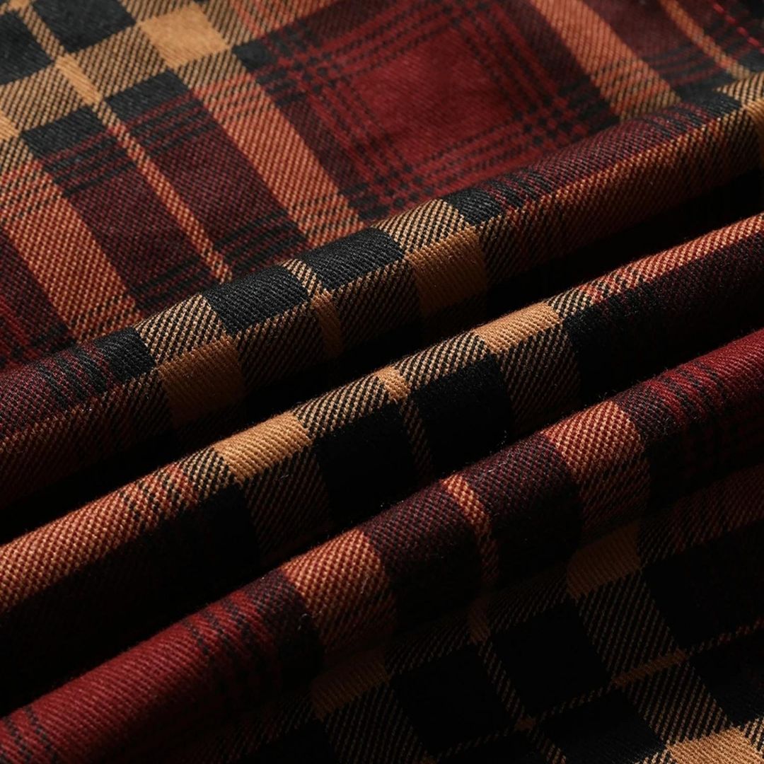 Tessuto scozzese in lana, motivo a quadri rosso e nero, texture morbida e calda, ideale per abbigliamento invernale e accessori moda.
