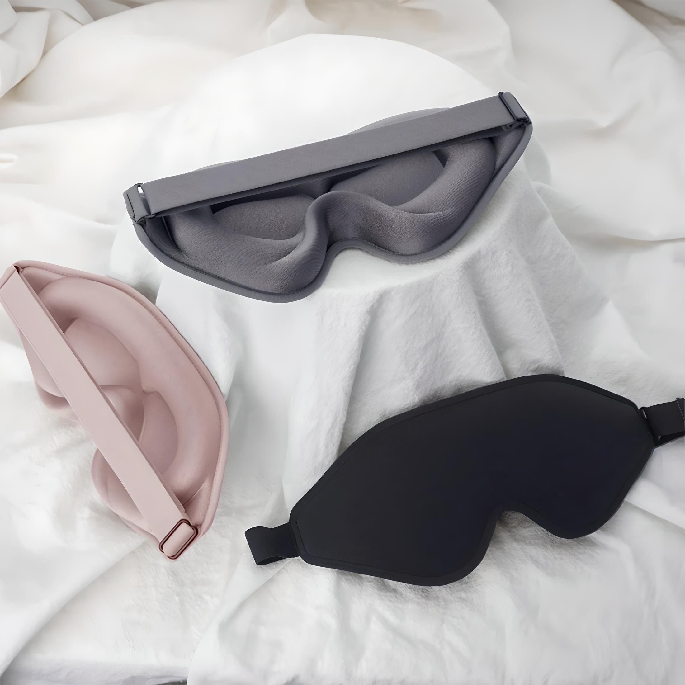 Maschere per dormire in tre colori: grigio, rosa e nero, su sfondo bianco. Accessori per il sonno, comfort, relax, blocco della luce.