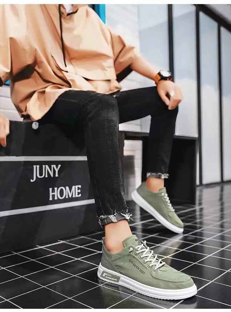Scarpe da ginnastica verdi da uomo su pavimento a scacchi, abbinate a jeans neri e camicia beige. Moda casual, stile urbano, calzature trendy.