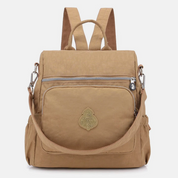 Zaino beige in tessuto resistente con tasca frontale con zip, spallacci regolabili e manico superiore. Design elegante e pratico per viaggi e scuola.