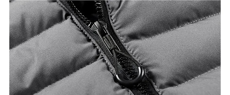 Giacca invernale imbottita grigia con cerniera nera, dettaglio tessuto resistente e cuciture rinforzate. Abbigliamento caldo e impermeabile.