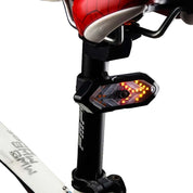 Sella bici con luce LED posteriore integrata, freccia direzionale, design moderno, accessorio sicurezza per ciclismo urbano e notturno.