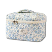 Borsa termica floreale bianca e blu con cerniera e manico, ideale per picnic e viaggi. Design elegante e pratico per conservare cibi e bevande.