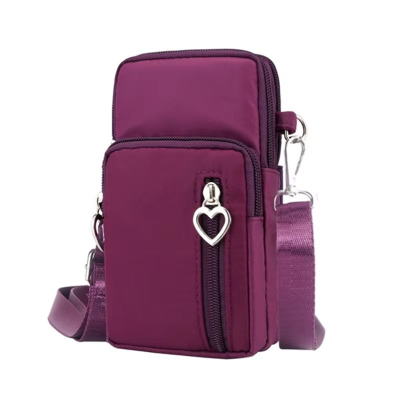 Borsa a tracolla viola in nylon con cerniera e decorazione a cuore, design compatto, ideale per smartphone e accessori. Accessorio moda donna.