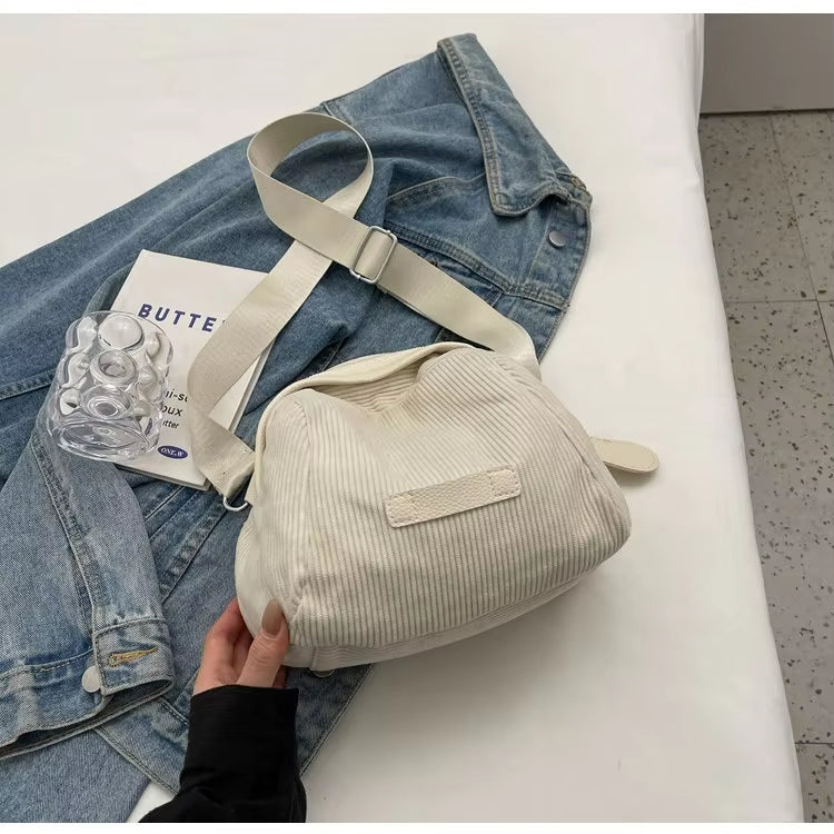 Borsa a tracolla bianca su giacca di jeans, design casual, tessuto a coste, accessorio moda donna, stile urbano, tendenza 2023.