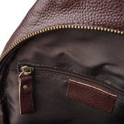 Zaino in pelle marrone con cerniera dorata, tasca interna con zip, tessuto resistente. Accessorio moda uomo e donna, elegante e pratico.