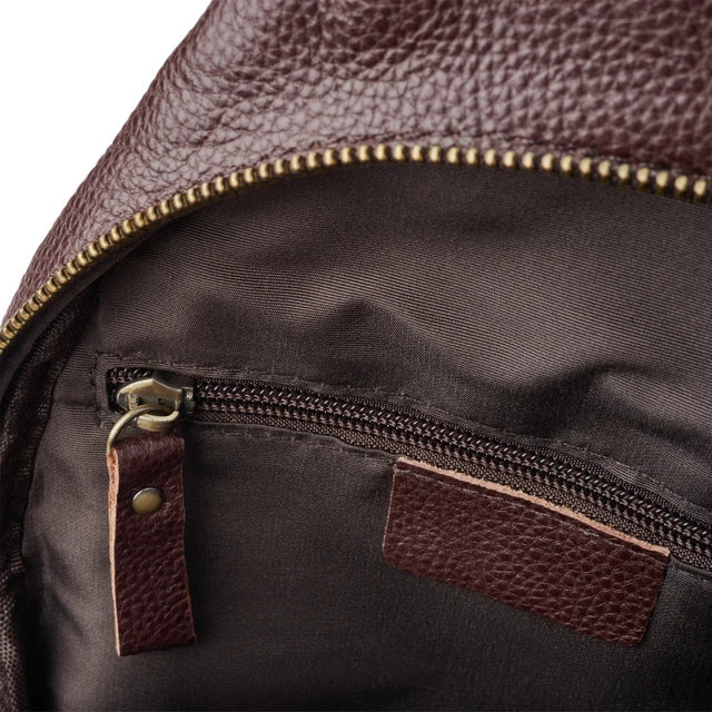 Zaino in pelle marrone con cerniera dorata, tasca interna con zip, tessuto resistente. Accessorio moda uomo e donna, elegante e pratico.