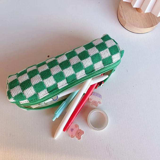 Astuccio a quadri verdi e bianchi su tavolo bianco, con penne colorate e adesivi. Accessorio scolastico, cancelleria per studenti.