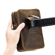 Borsa a tracolla in pelle marrone, design compatto, chiusura con zip, ideale per uomo, accessorio moda, pratico per viaggi e uso quotidiano.