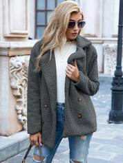 Donna con cappotto in pile grigio, jeans strappati e occhiali da sole, passeggia in città. Moda autunnale, abbigliamento casual elegante.