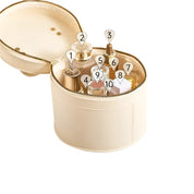 Scatola rotonda in pelle beige con cerniera, contenente flaconi di profumo e cosmetici. Elegante organizer da viaggio per prodotti di bellezza.