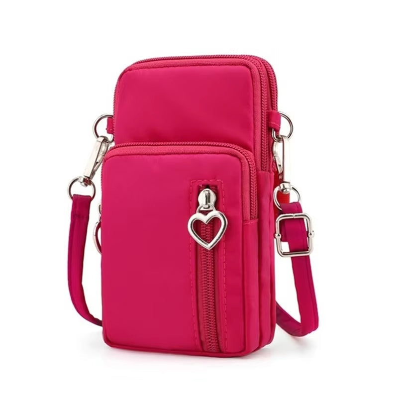 Borsa a tracolla rosa con cerniera e ciondolo a cuore, design compatto, ideale per smartphone e accessori. Accessorio moda donna elegante.