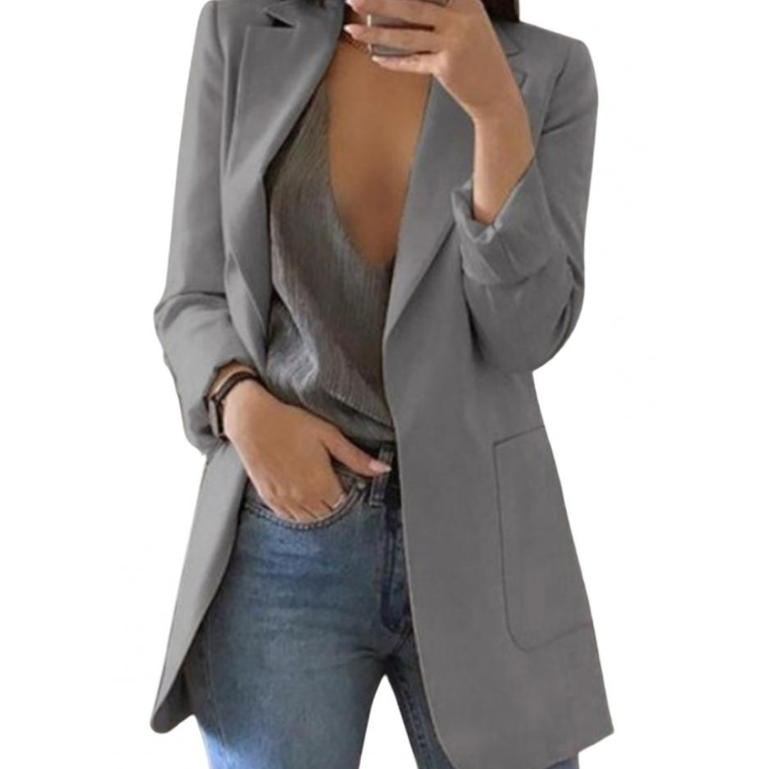 Giacca blazer grigia da donna, elegante e moderna, abbinata a top scollato e jeans. Moda femminile, abbigliamento casual chic.