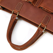 Borsa in pelle marrone con manici robusti e cuciture bianche, design elegante e resistente, ideale per lavoro e viaggi. Accessorio moda di qualità.