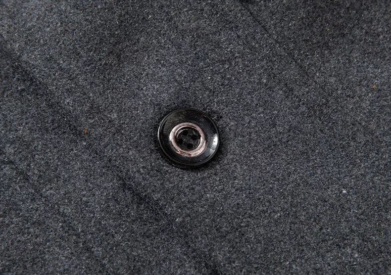 Pulsante nero su tessuto grigio in lana, dettaglio moda abbigliamento invernale, texture elegante e raffinata, ideale per cappotti e giacche.