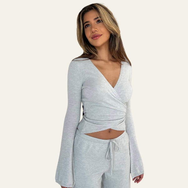 Donna con maglia grigia a maniche lunghe e pantaloni coordinati, stile casual elegante. Abbigliamento donna, moda autunno, look confortevole.