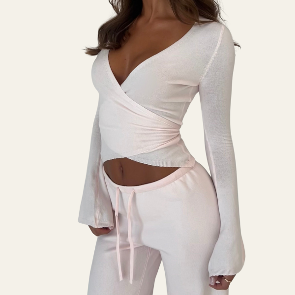 Top bianco a maniche lunghe con scollo a V profondo e pantaloni coordinati, abbigliamento donna elegante, moda casual, tessuto morbido.