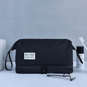 Nécessaire da viaggio nero con cerniera, etichetta "Light Travel", rasoio, spazzolino e flacone bianco. Accessori bagno eleganti e pratici.